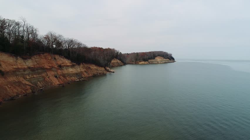 A 4k aerial drone perspective of Calvert Cliffs State Park along the Chesapeake Bay in Maryland on a fall afternoon in December. The park is known for its abundance of Middle Miocene Era fossils.