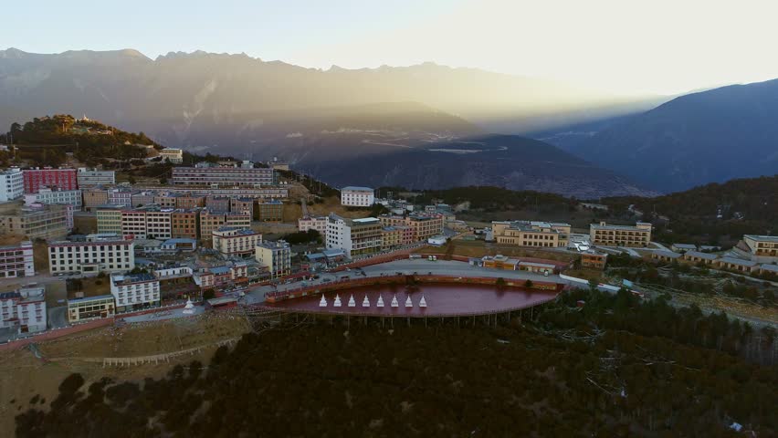 aerial view of modern buildings  near green hill in blue sky