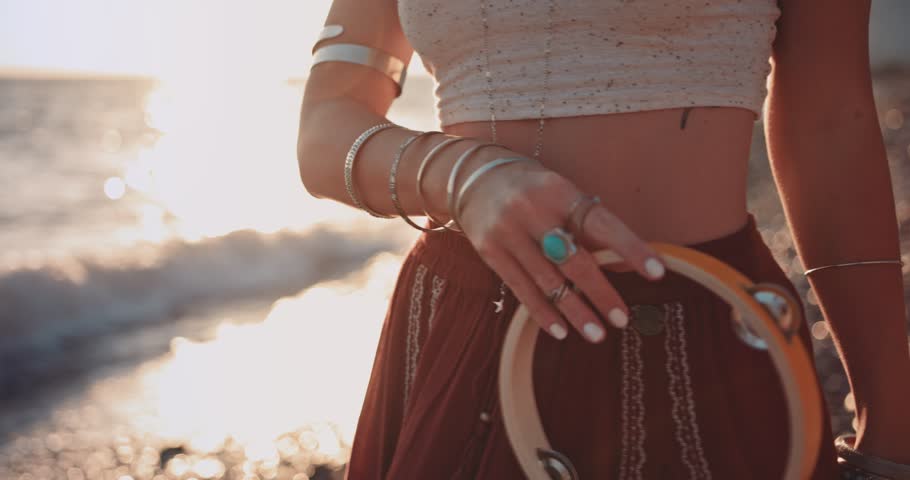 Close-up of young bohemian woman playing the tambourine at beach music festival at sunset Royalty-Free Stock Footage #33634075