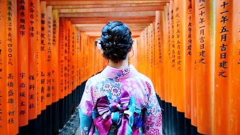 Asian women in traditional japanese kimonos walking at Fushimi Inari Shrine in Kyoto, Japan.