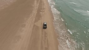 Footage of extreme lovers driving on rented automobile with dust along sea coastline on off road preparing for rally competition.Video of trip by leased car on shore near sea with blue waves