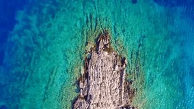 Aerial drone bird's eye view video of tropical rocky islet with turquoise and sapphire clear waters