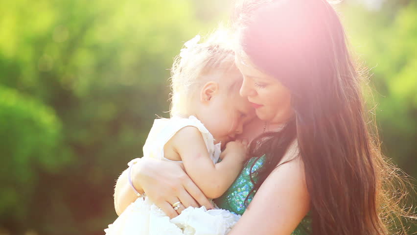 Sunny child and mother. Mother looking at camera. Lens flares