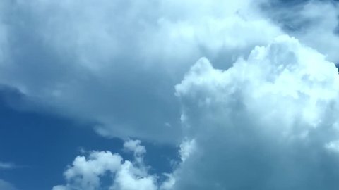 White puffs of clouds float across a summer blue sky. Time lapse clip passing by. Fairly good summer weather with nice. FHD. Clear natural sunny day.