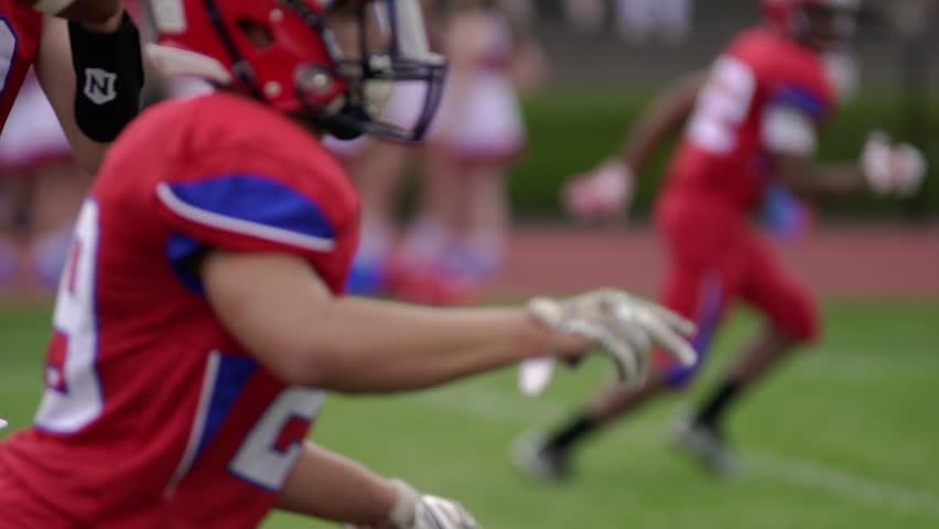 High school quarterback receives snap, in slow motion