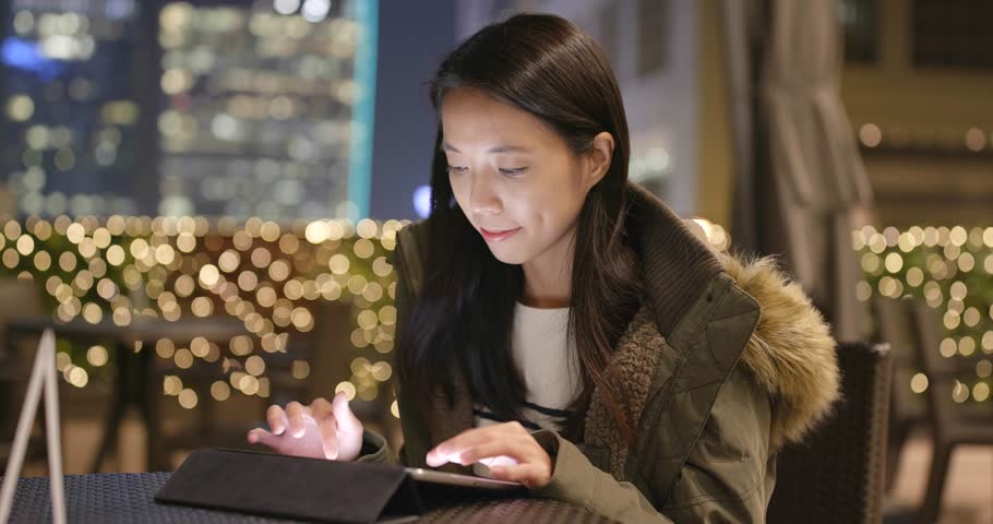 Woman use of digital tablet computer at night
