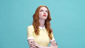 Displeased ginger woman in dress receives but still was not happy after that over blue background