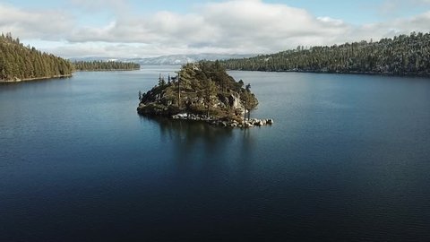 drone flying over Emerald Bay approaching Fannett Island and then rotates around the island keeping the island in frame. partly cloudy day