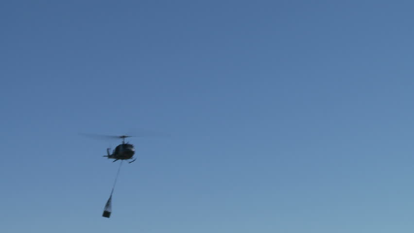An Iroquois military helicopter carrying supplies in flight 