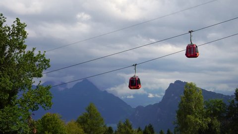 Red cable car gondola passing Lake Lucerne hills in Swiss Alps in Switzerland 