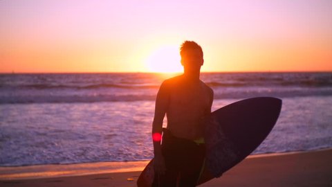 Model surfer with surf board posing in front of camera. Sunset vocation mood. The zen of surfing. Love action sports. What to do on the beach in winter. Like a pro.