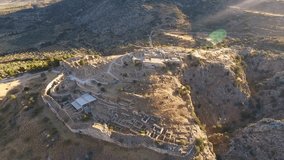 Aerial bird's eye view video taken by drone of iconic archaeological site of ancient citadel of Mycenae, Peloponnese, Greece