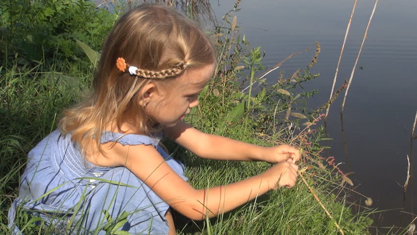 Child Playing with a Stick in Water, Little Girl Playing Near a Lake