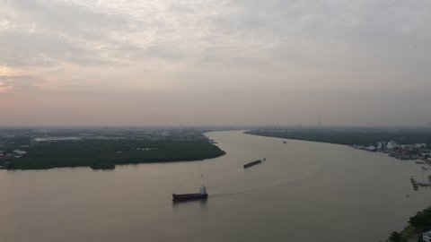 Aerial view of tugboat and Cargo transport ship passing industrial area in Chao Phraya river. Bangkok, Thailand