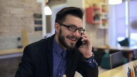 Young happy businessman talking on the phone