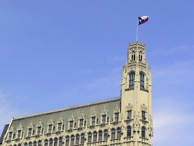Emily Morgan Hotel across from the Alamo in San Antonio Texas. Historic building with Texas flag flying on top. 