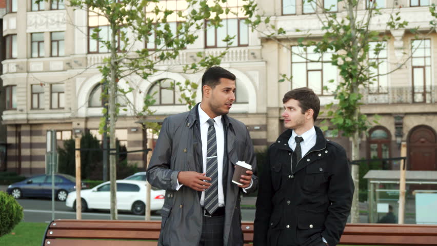 The strolling men discuss something serious