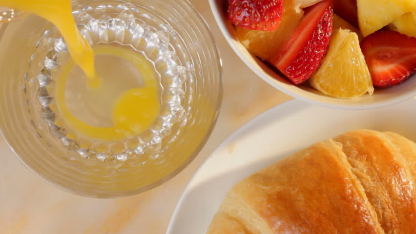 Pouring orange juice at breakfast