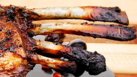grilled ribs on wooden table with pomegranate beens hidef slow motion intro