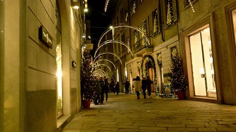 MILAN, ITALY - DECEMBER 7:   people strolling in Spiga street Christmas lights  in the middle of luxury fashion shopping precinct,  shot on patron saint festival evening, dec 7 2017 Milan, Italy