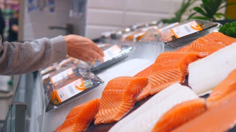 Woman Customer Choosing Fresh Salmon In Supermarket. Close Up. 4K. 
