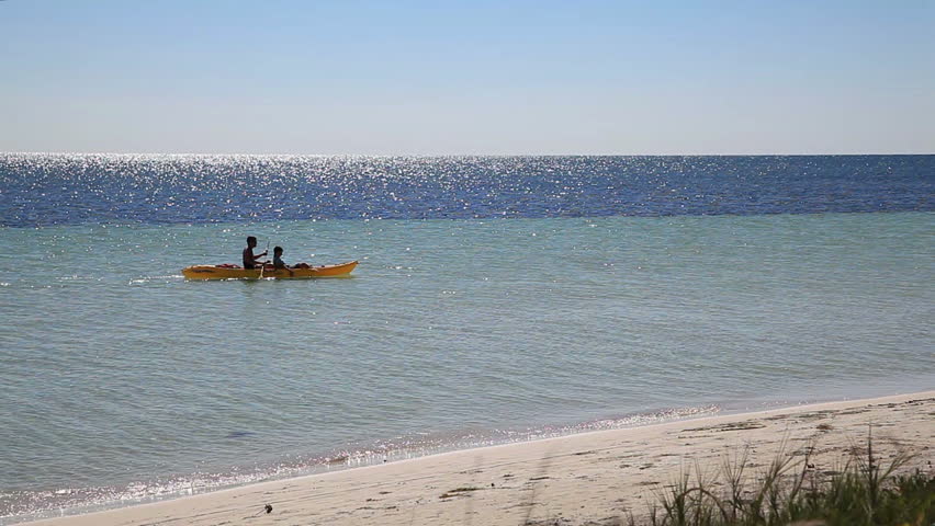 young adults kayaking in ocean