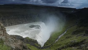 Picturesque landscape of a mountain waterfall and traditional nature of Iceland. Slow Motion Footage.