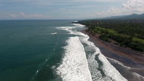 Bird's eye view of ocean surface and coastline of island for weekend recreation with green flora and beautiful natural landscape, video of deep sea waves moving to shore of cove foaming near beach