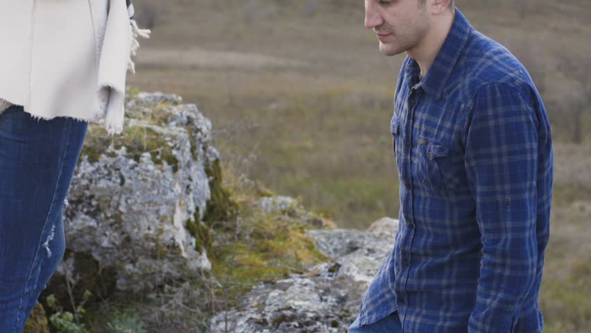 Lovely man twists his pretty girl on the hands on nature. Slowly.