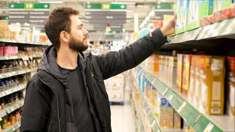 Man checking food labelling in supermarket. 4K UHD