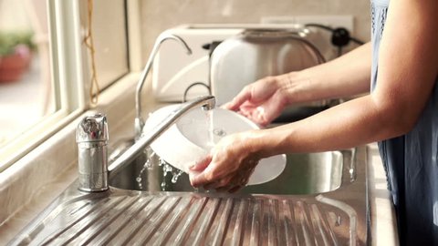 Woman washing plate in kitchen sink, super slow motion, shot at 240fps
