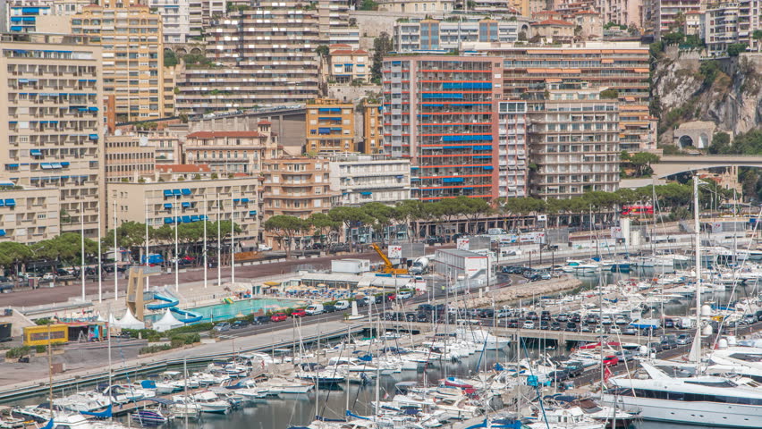 Seaside swimming pool in Monaco timelapse, with people and buildings in the background. Aerial top view. Traffic on the road