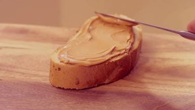Peanut butter paste spread on bread in slow motion