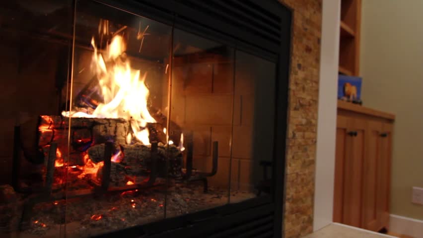 A jib shot of a roaring fireplace in a farmhouse.