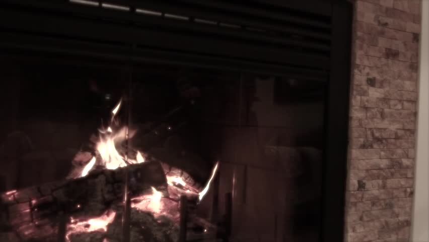 A jib shot of a roaring fireplace in a farmhouse.