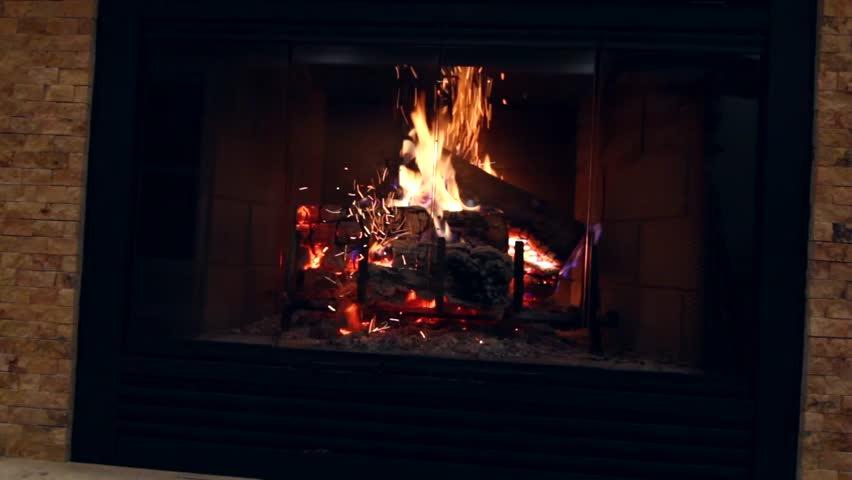 A jib shot of a roaring fire in a country home