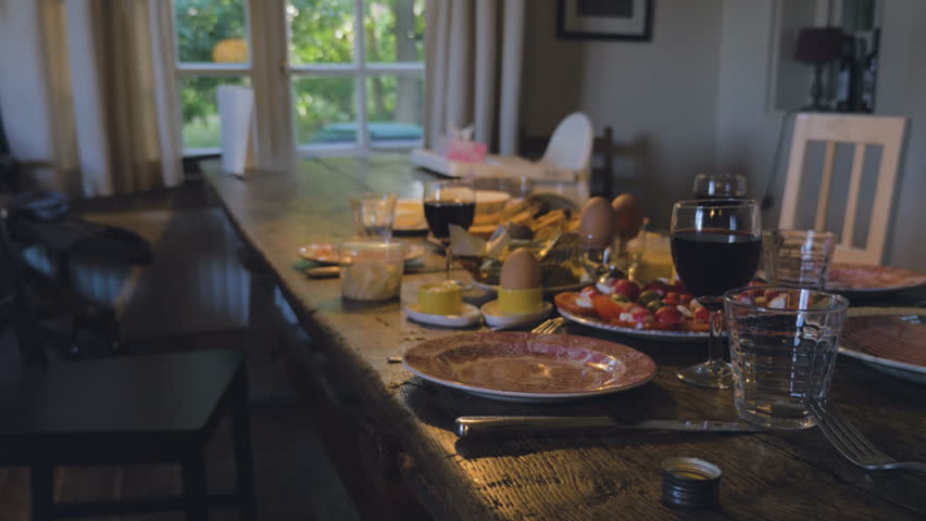 Old fashioned wooden table set with foods and wines. Long shot. 