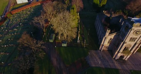 Aerial footage of the ruins of the High Kirk of Campsie, also referred to as Campsie High Church and Campsie Parish Church, in the village of Lennoxtown in Scotland beneath the Campsie Fells.