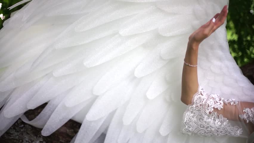 Girl stroking the wings of an angel. Street, good weather.