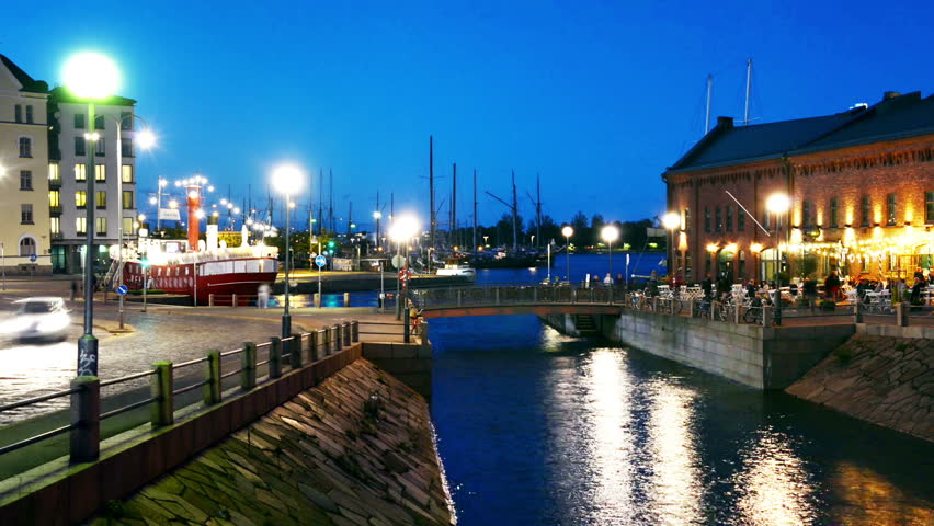 Helsinki, Finland. Love bridge at night. Car traffic trails with boats at the background. Famous cafe in Helsinki, Finland. Time-lapse
