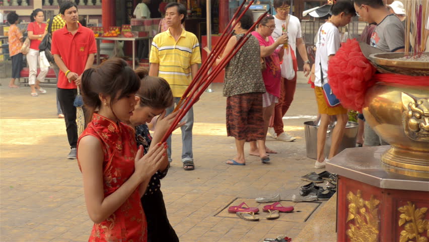 BANGKOK, THAILAND  - FEBRUARY 9, 2013: Young Thai-Chinese women making merit and