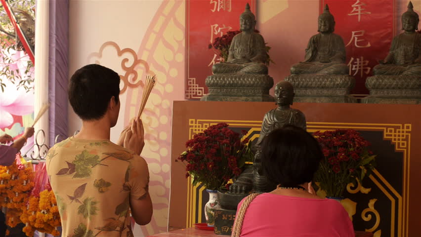 BANGKOK, THAILAND  - FEBRUARY 9, 2013: Thai people praying to Buddha and a monk
