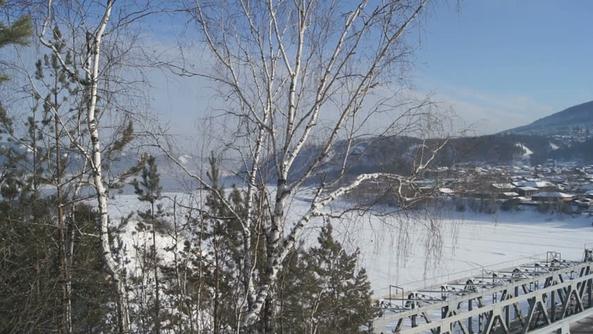 Road-railway bridge over the Siberian river Mana (village of Ust-Mana) on a sunny winter day, landscape, panning right. Krasnoyarsk territory, Siberia, Russia. February 04, 2013.