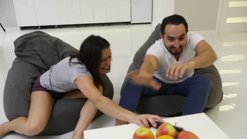 4K Couple fighting over the remote control in front of TV | Shutterstock HD Video #33779992