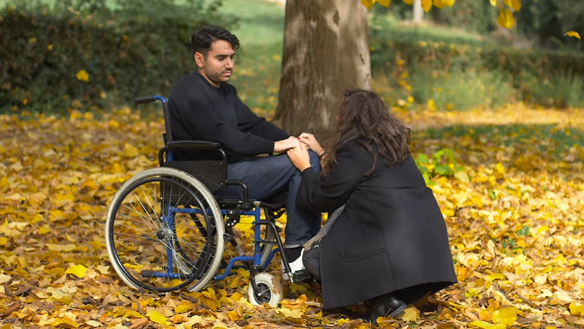 woman declares her love to a man on the wheelchair at the park