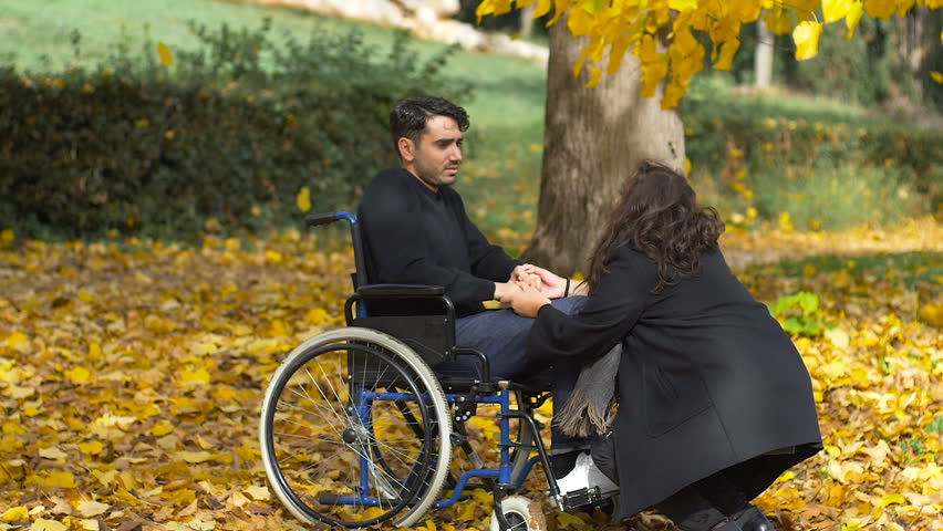 disabled man on wheels chair with girlfriend at autumn park