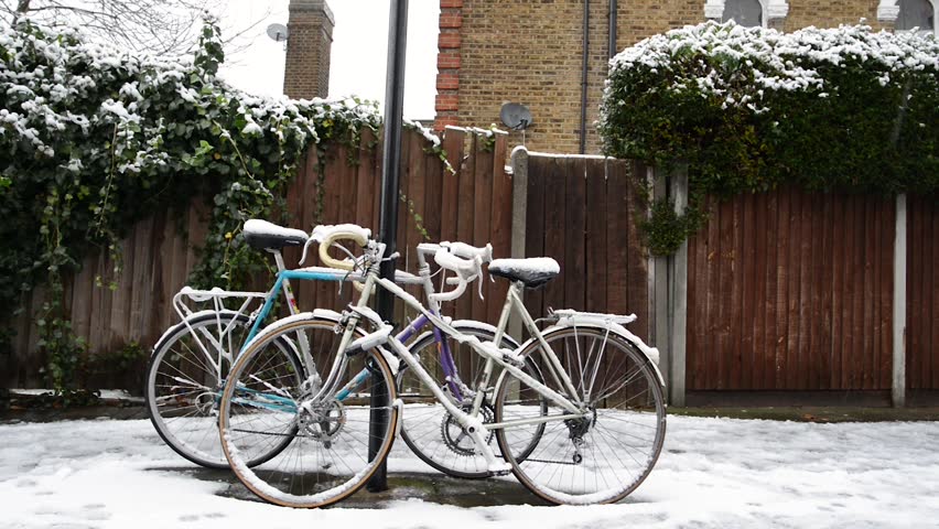 Two bikes covered by snow