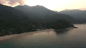 Video of tropical environment on exotic island with high mountains and cottages for tourism.Aerial scenery footage of touristic isle in Thailand with green trees and beautiful seashore