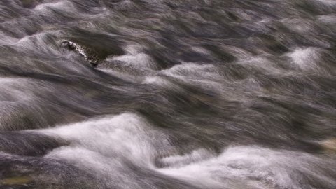HD - A time lapse river flows over rocks (Loop).