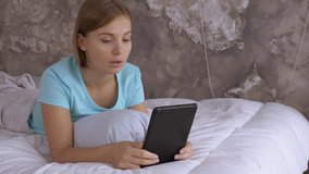 young caucasian woman has online video call at home using digital tablet. beautiful student use app for call in bedroom
